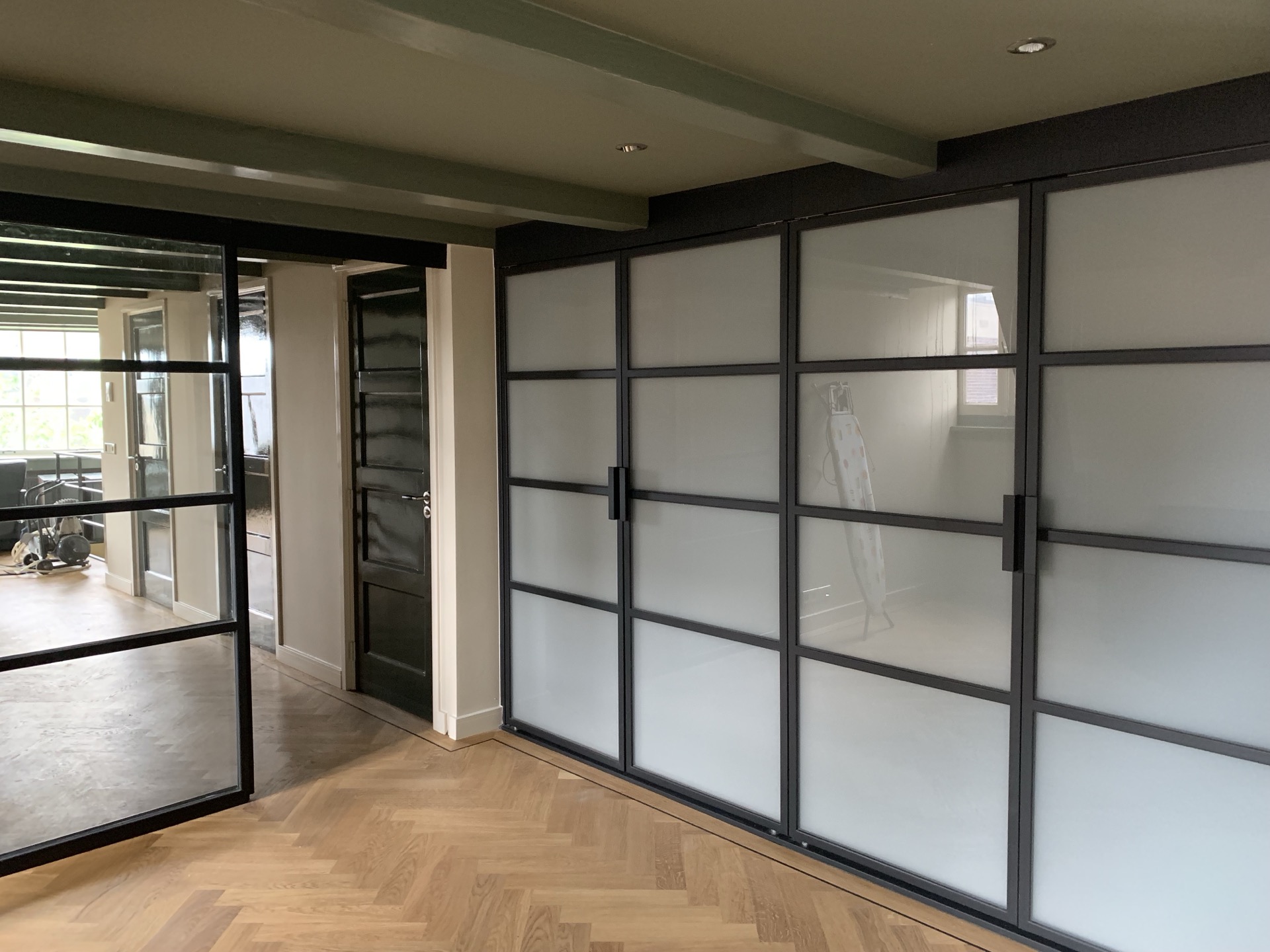 Interieur met stalen kozijnen en visgraat parket
